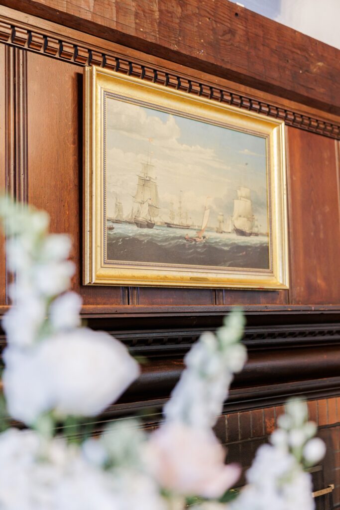 Gold-framed sailing-ship painting above the fireplace in the Salem Country Club wedding ceremony room.