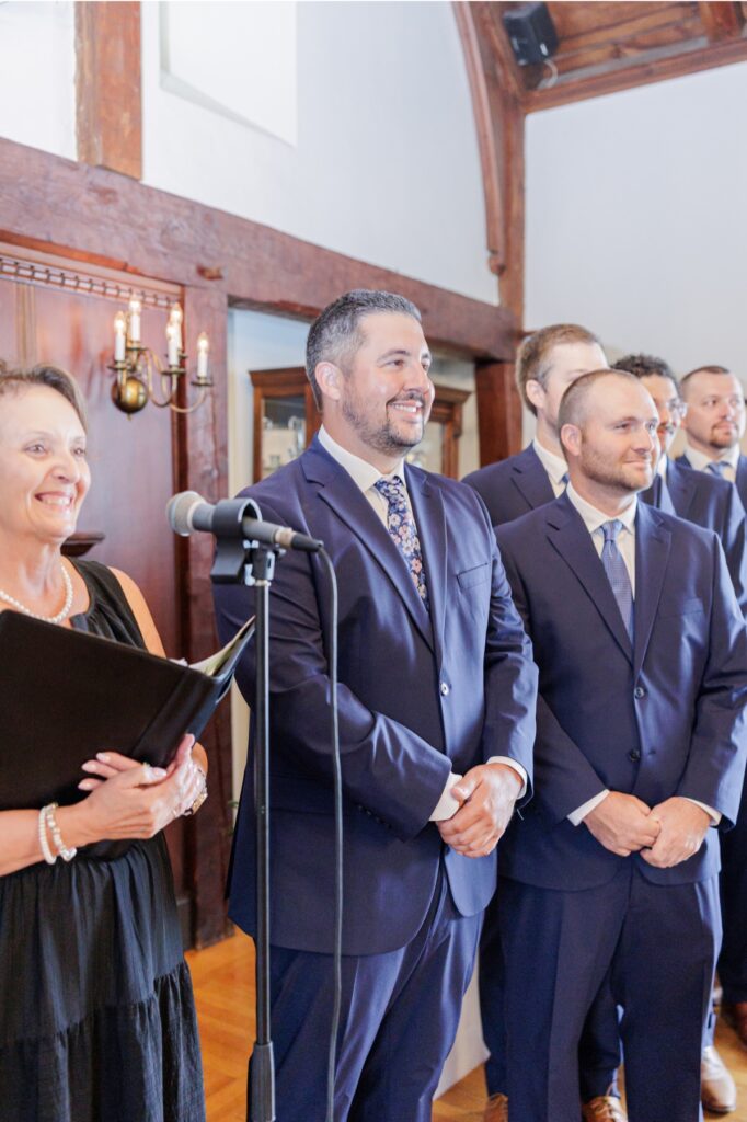 The groom smiling beside the officiant and groomsmen during his Salem Country Club wedding ceremony.
