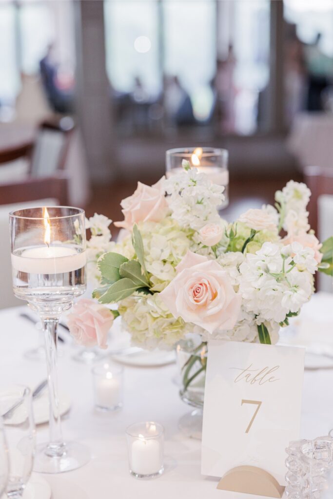 Blush and white floral centerpiece surrounded by floating candles at the Salem Country Club wedding reception.