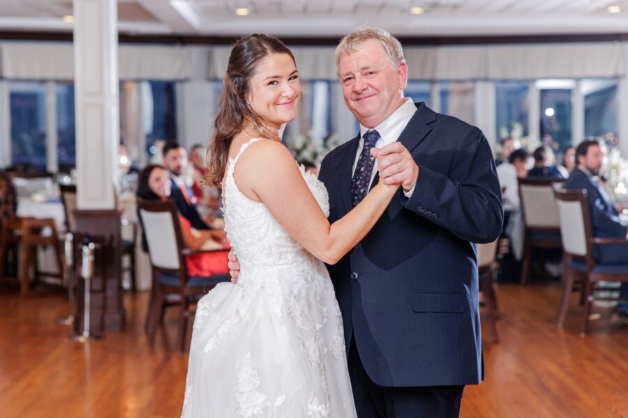 The bride and her father smiling toward the camera during their Salem Country Club wedding reception dance.