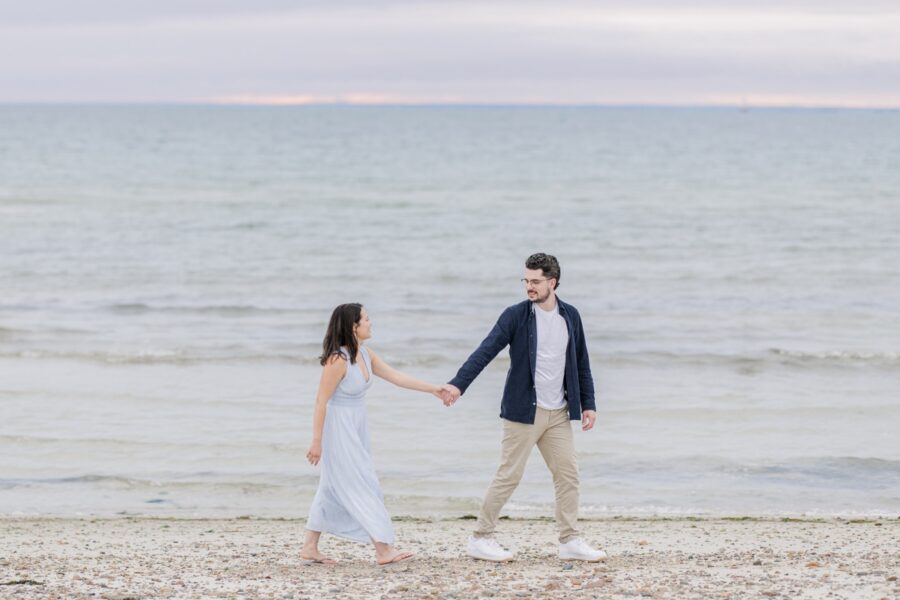 Couple holding hands along the shoreline at Old Silver Beach.