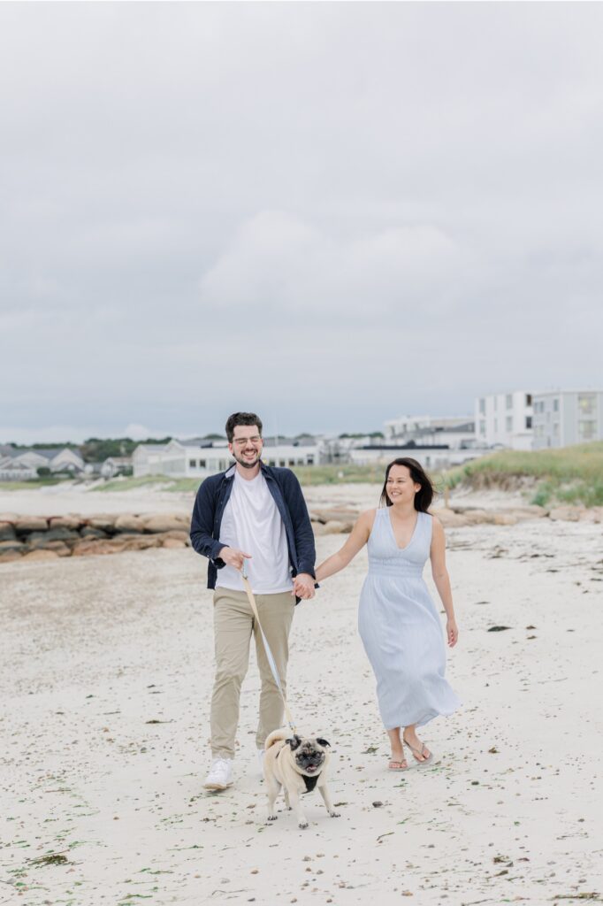Couple laughing and walking hand in hand on Old Silver Beach.
